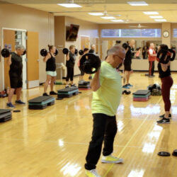 Instructor leading fitness group x fitness class.